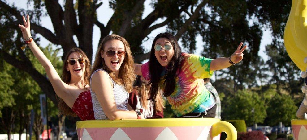 Students riding a tea cup at a carnival 